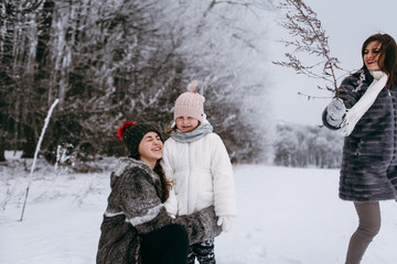 Fototapeta na wymiar Happy family. Mother and child daughters on a winter walk outdoors. 