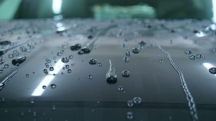 At the car wash, after washing, water drops and wax flow down the windows. Concept of: Window...