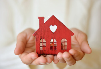 Warm and cozy miniature house in female hands. Care and love. 