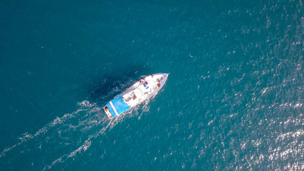 Fototapeta na wymiar Aerial image of a small fishing boat roaring along The Mediterranean sea