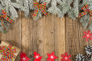 The branch of spruce with a gift on old wooden table.