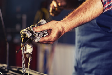 Closeup of the hand of car mechanic checking oil