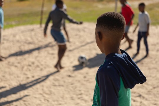 Boy Looking At The Kids Playing Football In The Ground