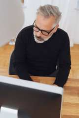 Businessman typing at his desktop computer