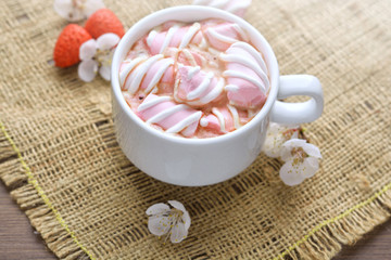 Fototapeta na wymiar Mug of hot coffee with marshmallows on a wooden background 