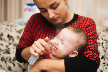 Mom makes inhalation of the child, holding hands