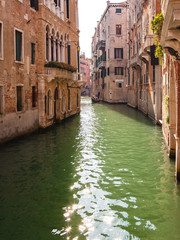 Gondola on narrow canal in Venice, Italy.