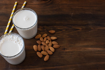 Almond milk with almond on a dark wooden table. Copy space
