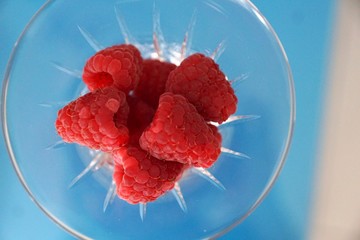 Himbeeren in einem glas auf dem blauen hintergrund