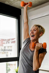 Portrait of senior woman lifting dumbbells