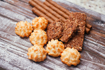 Mix of sweets. on wood table. Christmas treat. Chocolate wafer rolls, coconut  cakes, cocoa cereal bar. 