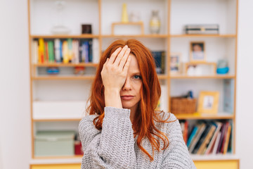 Woman covering her one eye with palm