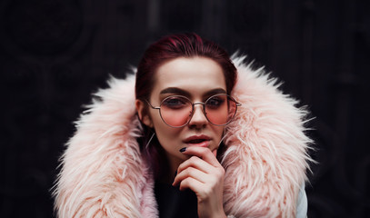 A girl is in red glasses, pink fur coat. Large portrait