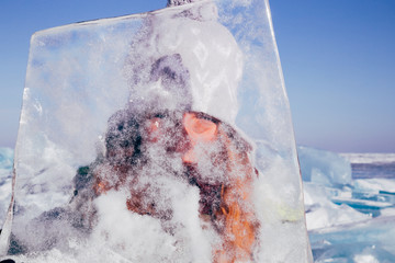 Traveling woman with block of ice gleaming in the sun. Winter tourism in Russia Baikal Lake.