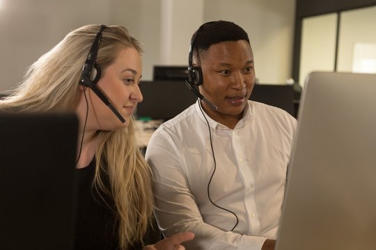 Customer service executives talking on headset at desk