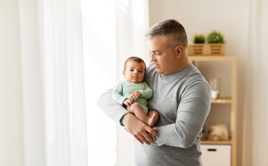 family, fatherhood and people concept - happy father holding with little baby son at home