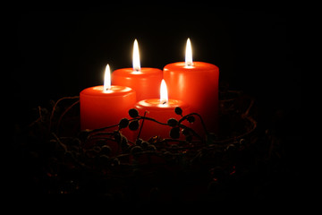 four red christmas candles with burning flames                              