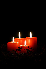 four red christmas candles with burning flames                              