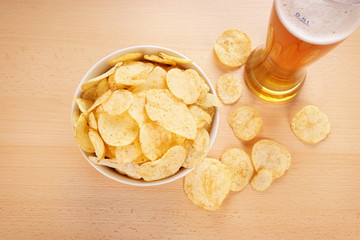 bowl of potato chips or crisps and a glass of wheat beer                               