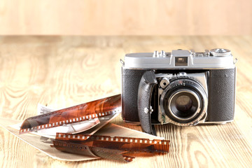 old camera, photograph print and negative film on a wooden table with copy space
