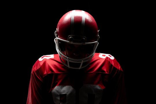 American football player standing with rugby helmat