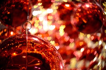 Red bauble ornament hanging to decorate for Christmas holiday in Bangkok Thailand with heart bokeh light in background.