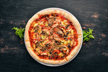 Pizza with chicken, vegetables and mushrooms. On a wooden background. Top view. Free copy space.