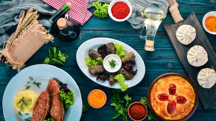 Assortment of dishes of Georgian and European cuisine. On the old wooden background. Free space for text. Top view.