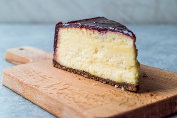 Raspberry Cheesecake Slice on Wooden Board with Paper.