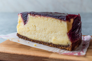 Raspberry Cheesecake Slice on Wooden Board with Paper.