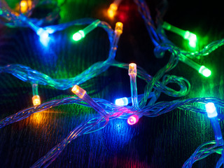 Christmas garland on a dark background. Glowing Christmas garland. New Year and Christmas decorations and backgrounds. nds. Selective focus.