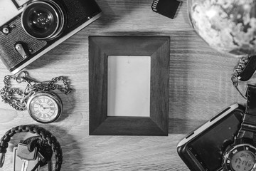 frame, Accessories for travel top view on wooden background with copy space. Adventure and wanderlust concept image with vintage camera. Preparing for an exotic trip, journey black and white
