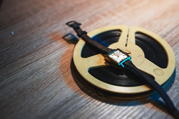 Retro audio reels and old Wrist Watch with copy space, top view, wooden table
