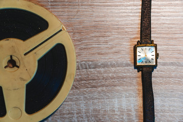 Retro audio reels and old Wrist Watch with copy space, top view, wooden table