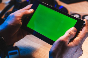 Man using tablet computer on the wooden table. Top view shot. the green screen. Chroma key.