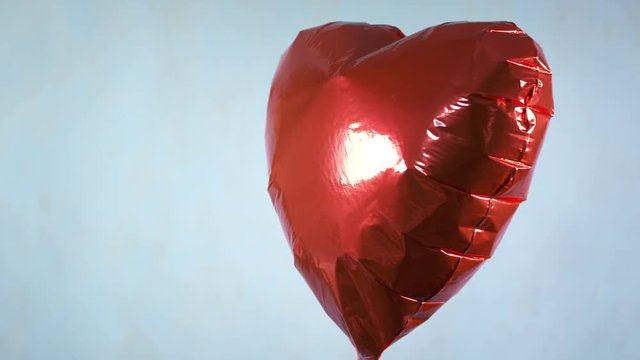 Red heart balloon on a blue background