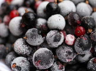 Frozen mixed berries as background. Currant mulberry texture pattern. Diet vegetarian food in winter.