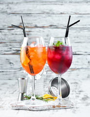 Two alcoholic cocktails. Aperol Sprits, Cocktail with currant. On a wooden background. Top view. Free copy space.