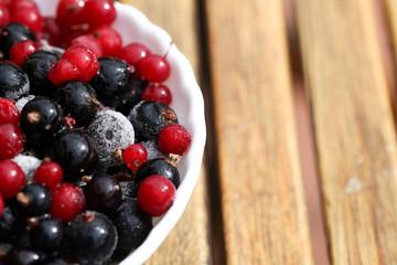 Frozen mixed berries as background. Currant mulberry texture pattern. Diet vegetarian food in winter.