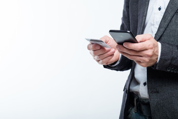 mobile payment and safe online transactions. digital finance. man holding credit card and phone.