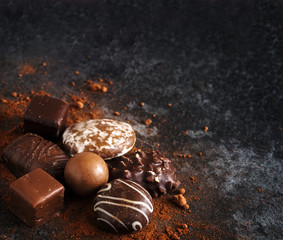 christmas chocolate cookies, gingerbread and pralines in the corner on a dark slate background with...