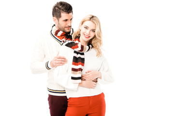 Romantic couple in knitted scrafs hugging isolated on white
