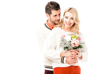 Handsome man hugging beautiful girlfiend with flowers isolated on white