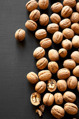 Many walnuts on black background, top view. From above, overhead.