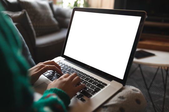 Woman using laptop in living room at home