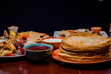 Shrovetide Maslenitsa festival meal. Russian pancakes blini with honey, fresh cream cheese and red...