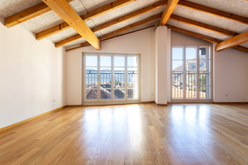 Room with wooden beams and large windows overlooking the Swiss Alps. Nobody inside