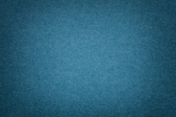 Texture of old navy blue paper background, closeup. Structure of dense denim cardboard.