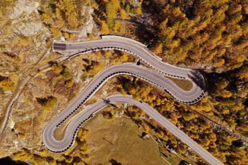 Aerial view of a mountain highway (street) while people go to work in a sunny day. Concept: Transport; Work.