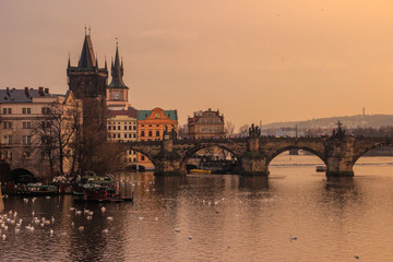 Fototapeta na wymiar Yellow sunset over the Vltava River and the Charles Bridge in Prague, Czech Republic.
